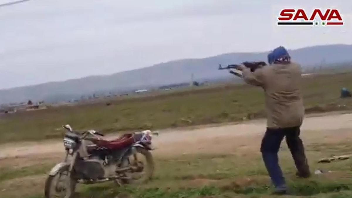 A handout image grab obtained from the official Syrian Arab News Agency (SANA) on February 12, 2020, allegedly shows a man opening fire against US military vehicles in the town of Kherbit Amo near the northeastern Syrian city of Qamishly. The US-led coalition said its forces in northeast Syria today confronted gunmen with live fire after one of its patrols came under attack near the city of Qamishli. According to the coalition forces spokesman Myles Caggins, the patrol encountered a checkpoint occupied by pro-Syrian regime forces and came under small arms fire from unknown individuals and in self defense the coalition troops returned fire. - == RESTRICTED TO EDITORIAL USE - MANDATORY CREDIT "AFP PHOTO / HO / SANA" - NO MARKETING NO ADVERTISING CAMPAIGNS - DISTRIBUTED AS A SERVICE TO CLIENTS == / AFP / SANA / STRINGER / == RESTRICTED TO EDITORIAL USE - MANDATORY CREDIT "AFP PHOTO / HO / SANA" - NO MARKETING NO ADVERTISING CAMPAIGNS - DISTRIBUTED AS A SERVICE TO CLIENTS ==