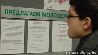 Человек перед доской объявлений с предложениями работы